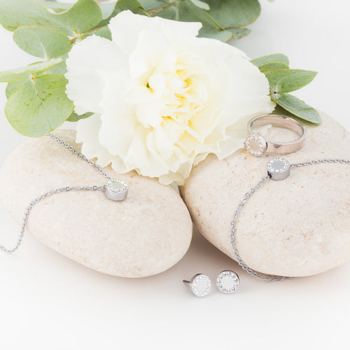 A collection of Titanium brilliance puck jewellery set consisting of earrings, ring, bracelet and necklace medical sensitive skin friendly nickel free