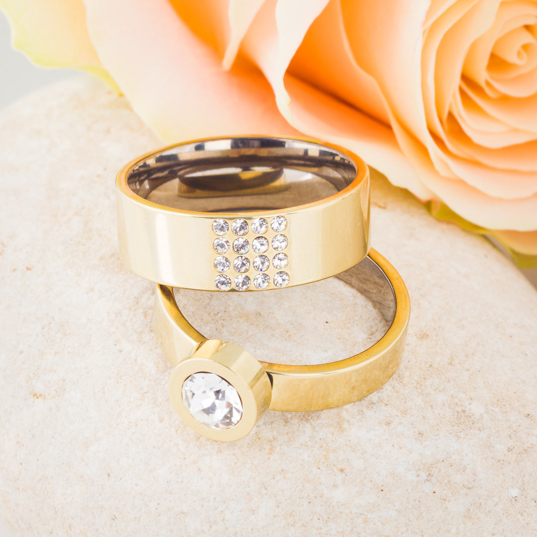 A collection of two gold rings - one is a brilliance square and the other is a grand bezel medical sensitive skin friendly nickel free