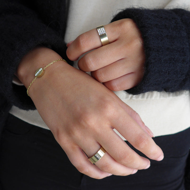 Lady wearing 2 gold titanium rings and a bracelet from Blomdahl medical sensitive skin friendly nickel free