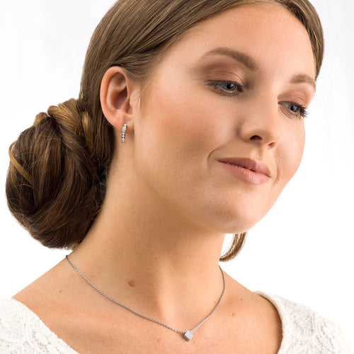 Woman wearing a silver brilliance square crystal necklace and brilliance curved crystal earrings medical sensitive skin friendly nickel free
