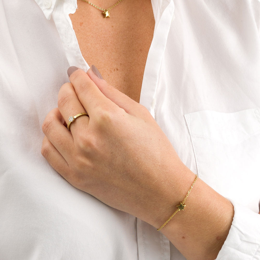 Showcasing gold star bracelet and necklace on a model with white top medical sensitive skin friendly nickel free